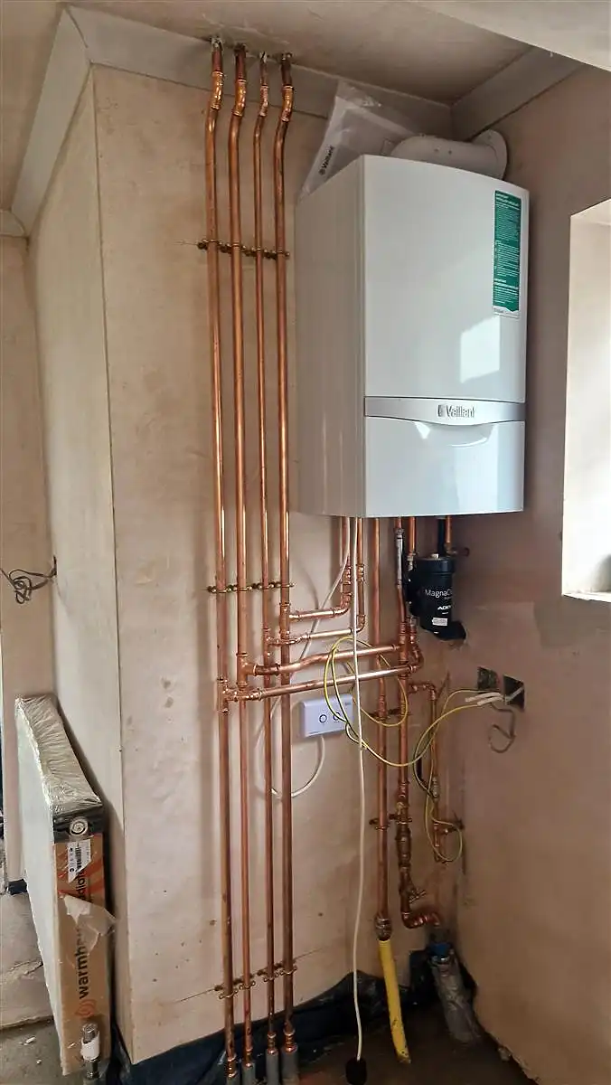 Newly installed Vaillant Gas boiler with neatly arranged copper piping in a residential setting.